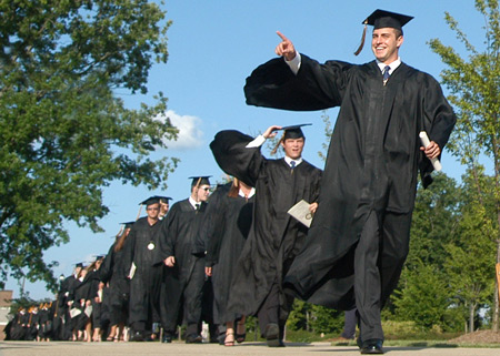 Economics/finance graduate Will Harris leads a trail of graduates toward the East Lawn for spring commencement exercises. - Photo by Jonathan Blair
