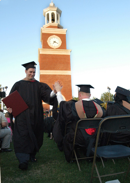 Graduation is truly a time of celebration as this student gets a high five after recieving his Master of Business Adminstration degree. - Photo by Kristen Hiller