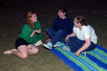 Art majors, Hannah Russell, Katie Williams, and Caitlyn Miller, laugh together while waiting for SAC's Movie on the Lawn, Sherlock Holmes 2, to begin. - Photo by Anne Richoux