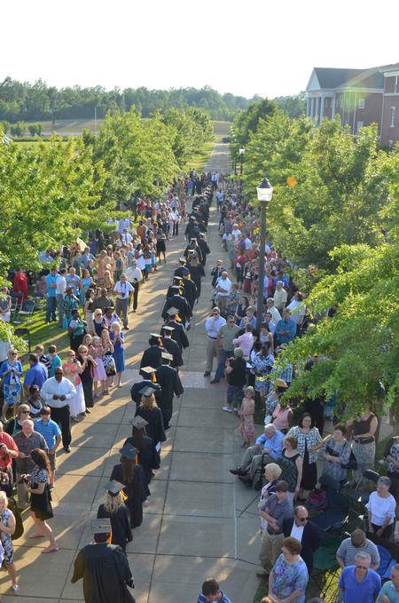 614 graduates walk past friends and family to the Great Lawn for spring graduation. - Photo by Morris Abernathy