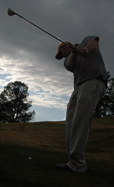 Freshman golfer Chase Whitby drives a ball on a cloudy day. - Photo by Jonathan Blair