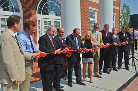 Vital members of the team that built the new Hendersonville facility, including Gary Carter, David S. Dockery, Jim and Janet Ayers, Norman Hill, Randy Davis, Scott Foster, Gene Fant, and two TLM representatives, cut the ribbon during the dedication ceremony. - Photo by Morris Abernathy