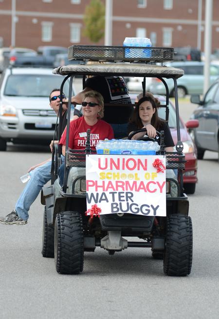 Sheila Mitchell, dean of the school of pharmacy, and Laura Ladymon, coordinator of experiential and continuing education, cart water around the residential complexes for those involved in new student move-in day. - Photo by Jacob Moore