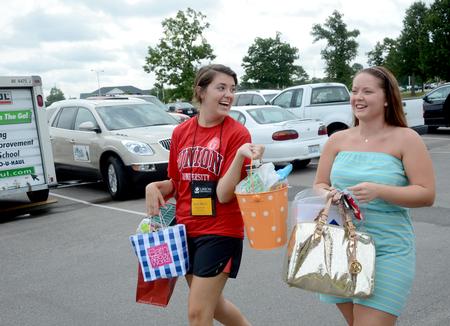 Anna Marie Deschenes, senior social work major, helps Kathryn Dunlap, incoming freshman, as she moves into her residence complex on new student move-in day. - Photo by Ebbie Davis