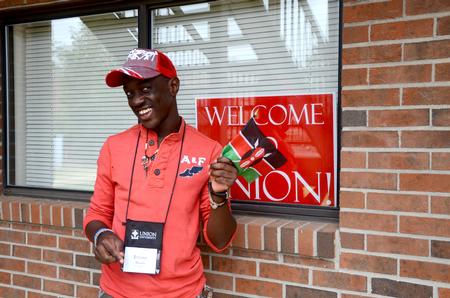 Jeremy Murila, freshman engineering major from Nairobi, Kenya, waves his country's flag after traveling over 8,200 miles to move into his room at Union on new student move-in day.  - Photo by Ebbie Davis