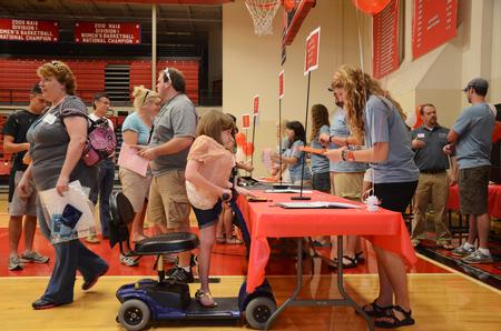 Brittany Ary, freshman undecided major, checks in with resident advisor Julia Marshall, senior special education major, to receive her dorm keys during new student move-in day. - Photo by Zac Calvert