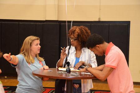 Kelly Rawls, junior sports medicine major, gives directions to Simone Cage, freshman marketing major, and his mother, Bobby, during new student move-in day.    - Photo by Zac Calvert