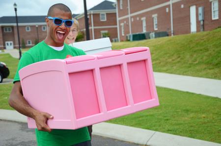 Jordan Timbs, senior physical education and health major, helps carry his LifeGroup member's dresser to her room during new student move-in day.  - Photo by Ebbie Davis