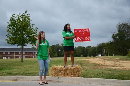 Madeleine Hemphill, psychology and business double major, and Abbie Perez, sophomore nursing major, greet new students at the Walker Road entrance during new student move-in day. - Photo by Zac Calvert