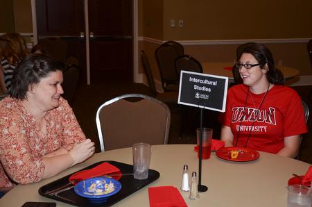 Aura Opris, intercultural studies program coordinator, shares a laugh with Makailah Bleedner, freshman intercultural studies major, as they discuss the benefits of the major during Dinner with you Department. - Photo by Zac Calvert