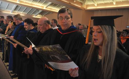 Randy Johnston, professor of chemistry and department chair, and Anika Strand, senior class president, sing during Fall Convocation. - Photo by Morris Abernathy