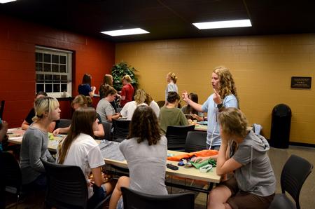 Julia Marshall (right), senior special education major, tells students how to make a craft during the residence life Ladies Night in the Bowld Student Commons.  - Photo by Anne Richoux