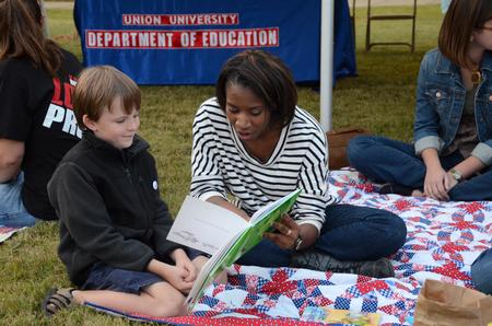 Amber Buggs, freshman elementary education major, reads a book to Caleb Brunet, son of Josh Brunet, at Union Night during Family Weekend. - Photo by Anne Richoux
