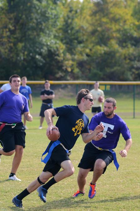 Jake Ryan, senior business administration major, runs with the football as Nathan Bibb, senior sports medicine major, tries to pull one of his  flags in an intramural game during Family Weekend. - Photo by Zac Calvert