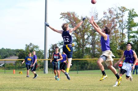 Aubrey Binkley, sophomore sports medicine major, and Matt Street, senior business administration major, jump for the football at an intramural game during Family Weekend. - Photo by Zac Calvert