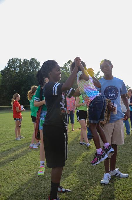 Richauna Kidd, sophomore accounting major, picks up her little sister Myia as her brother, Richard, watches after an intramural game during Family Weekend. - Photo by Zac Calvert