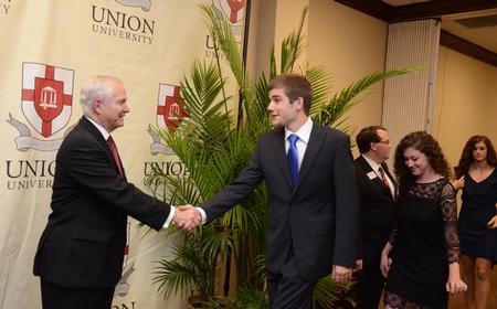 Joey Davis, junior business administration major, greets Robert M. Gates, former U.S. secretary of defense, after the 15th Annual Scholarship Banquet. - Photo by Jacob Moore