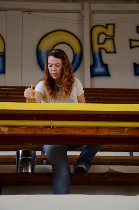 Natalie Schklar, senior social work major, paints tables in North Side High School's gym during Union's tenth annual Campus and Community Day. - Photo by Anne Richoux