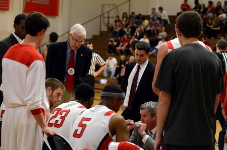 James Patterson, honorary coach and associate dean of the school of theology and missions, and Trevor Lydic, assistant coach, listen as David Niven, head coach, talks with the Bulldog basketball team during a time-out in a game against Central Baptist College.  - Photo by Anne Richoux