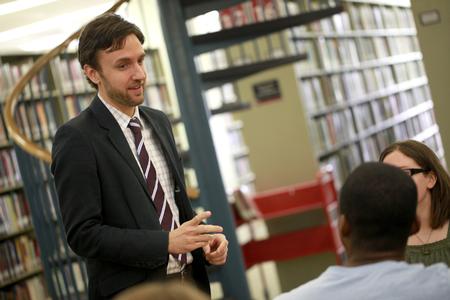 Jason Crawford, assistant professor of English, talks to a couple of students in the library.  - Photo by Kristi McMurry Woody