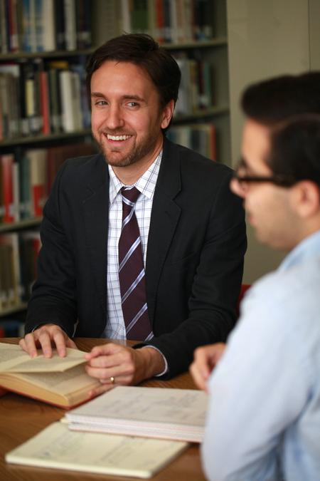 Jason Crawford, assistant professor of English, meets with a group of students in the library.  - Photo by Kristi McMurry Woody