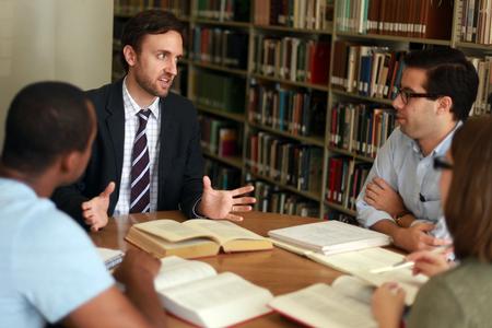 Jason Crawford, assistant professor of English, chats with a group of students in the library.  - Photo by Kristi McMurry Woody