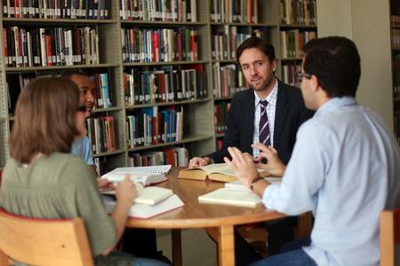 Jason Crawford, assistant professor of English, meets with a group of his students in the library.  - Photo by Kristi McMurry Woody