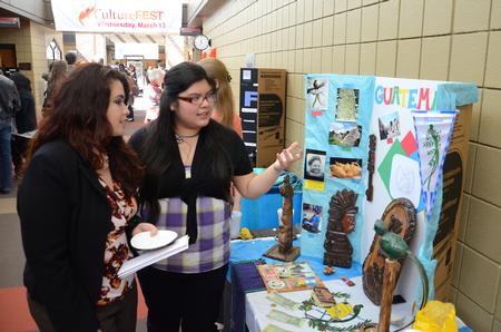 Sophomore Alma Hernandez talks about Guatemala with Esperanza Aguilar, secretary and student success advocate for the Vocatio Center, during the CultureFEST culture fair. - Photo by Jacob Moore