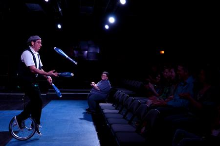 Guest artist Doug Berky juggles and rides a unicycle as a part of his performance of "No Show"  in the W.D. Powell Theatre.  - Photo by Anne Richoux