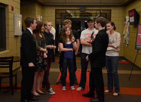 James Watlington, sophomore media communications major and co-host of the Student Film Festival, interviews the cast and crew of "That's How It's Done" on the red carpet outside Barefoots Joe. - Photo by Jacob Moore