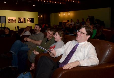 Chris Blair, professor of communication arts and coordinator of DMS, laughs with the crowd while hosts at the Student Film Festival crack jokes in between giving out awards. - Photo by Jacob Moore