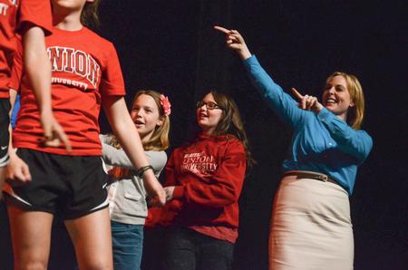 Kimberly Thornbury, vice president for student services and dean of students, joins the Student Athlete Advisory Committee onstage at the 16th annual Variety Show with her two daughters. - Photo by Jacob Moore