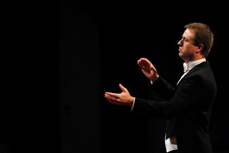Chris Mathews, associate professor of music and department chair, conducts during the Spring Choral Concert at First Baptist Church.  - Photo by Anne Richoux