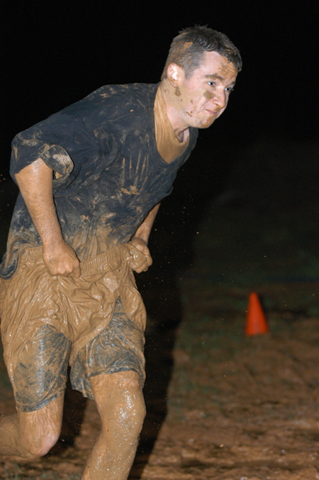 Junior Justin Belsly struggles toward the finish line during the Young Alum's Midnight Mudness. - Photo by Jonathan Blair