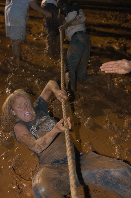 Junior Ruth Schroeder struggles as her team competes in a tug-of-war during the Young Alum's Midnight Mudness. - Photo by Jonathan Blair