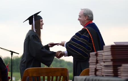 Sam Adams, public relations graduate, receives her diploma from David S. Dockery, president of the university, during Spring Graduation. - Photo by Jacob Moore
