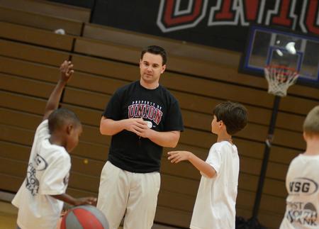 Trevor Lydic, assistant men's basketball coach, works with children participating in the athletic department's basketball Pee Wee Camp held in the Fred DeLay Gymnasium. - Photo by Jacob Moore