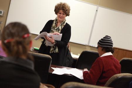 Luanne Powell, director of the McAfee School of Business Administration, hands out papers at the beginning her class.  - Photo by Kristi McMurry Woody