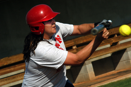 Freshman Leanne Closson, sport management major, prepares to hit the ball during softball practice. - Photo by Jonathan Blair