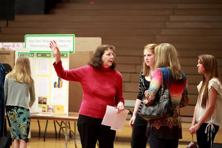 Sally Henrie, professor of chemistry, directs guests at the Science Fair held in the Fred Delay Gym. The fair is hosted for area schools and judged by several community members and Union faculty and students.  - Photo by Kristi McMurry Woody