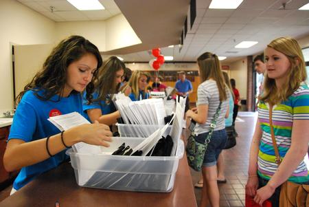 Melanie Arias, senior social work major, helps freshman Hannah Porter get checked in during move-in day.  - Photo by Anne Richoux