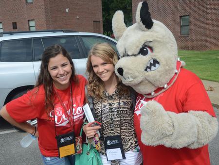 Jenna Ward, junior, and Christina Young, freshman nursing major, pose with Buster the Bulldog on new student move-in day. - Photo by Matt McDaniel