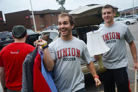 Trey Scogin, junior athletic training major, and Caleb Mills, junior business administration major, help a freshman move in during new student move-in day. - Photo by Matt McDaniel