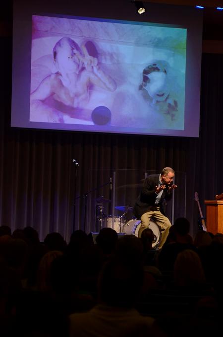 Todd Brady, vice president for university ministries, tells a story about his sons to new students and their families as an illustration during chapel. - Photo by Anne Richoux