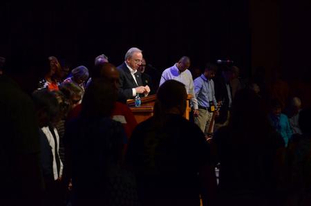 Faculty, staff, upperclassmen, and families members surround new students as David S. Dockery, president of the university, prays for them as they begin their university years. - Photo by Anne Richoux