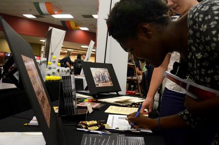 Monique Dailey, senior psychology major, signs up for more information from Indigenous Outreach International, one of many missions organizations that had displays at the GO Week Expo in Brewer Dining Hall. - Photo by Anne Richoux