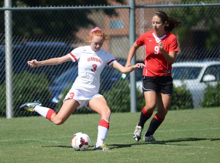 Kayleigh Patterson, freshman broadcast journalism major, passes the ball around a Union alumnus at the alumni soccer game during Family Weekend. - Photo by Matt McDaniel