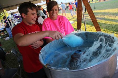 Daniel Roberts, sophomore business administration major, stirs cotton candy with Brittney Teel, senior nursing major, at Union Night during Family Weekend.  - Photo by Matt McDaniel