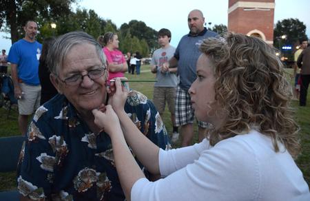 John Hudson, grandfather of student Nathan Shoemaker, gets his face painted by Bethany Kindt, sophomore art major, during Union Night on the Great Lawn. - Photo by Jacob Moore