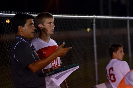 Head coach Clovis Simas talks with Bullog Caleb Mills prior to sending him back on the field during a soccer game against Christian Brothers University. - Photo by Anne Richoux